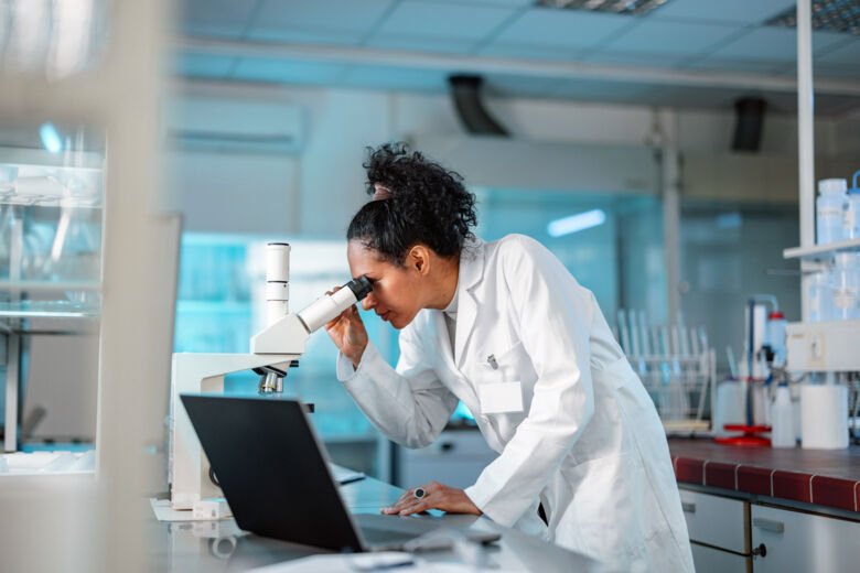 Scientists looking into her microscope