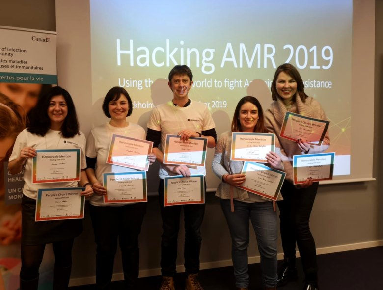 Marmar Nekoro, Elisabeth Reithuber, Oliver Dyar, Erika Saliba Gustafsson, Egle Obcarskaite standing in a row smiling holding up their diplomes that reads: People's Choice Award.