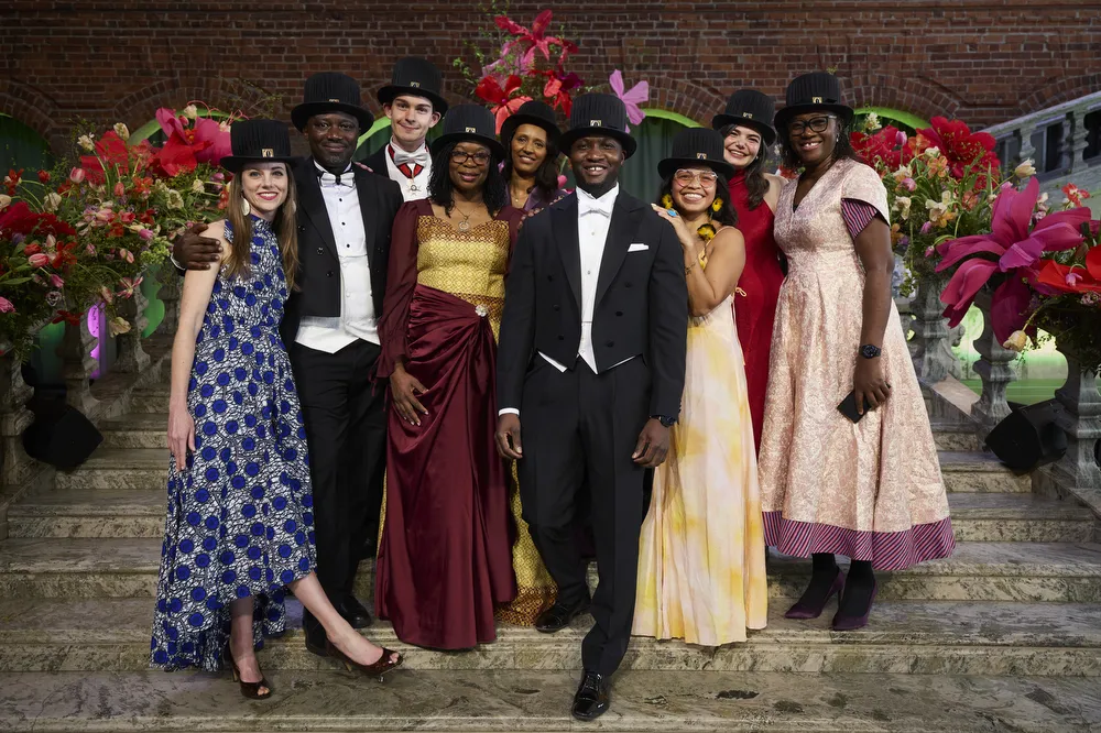 A group photo of newly graduated doctors from the Department of Global Public Health dressed in formal attire.