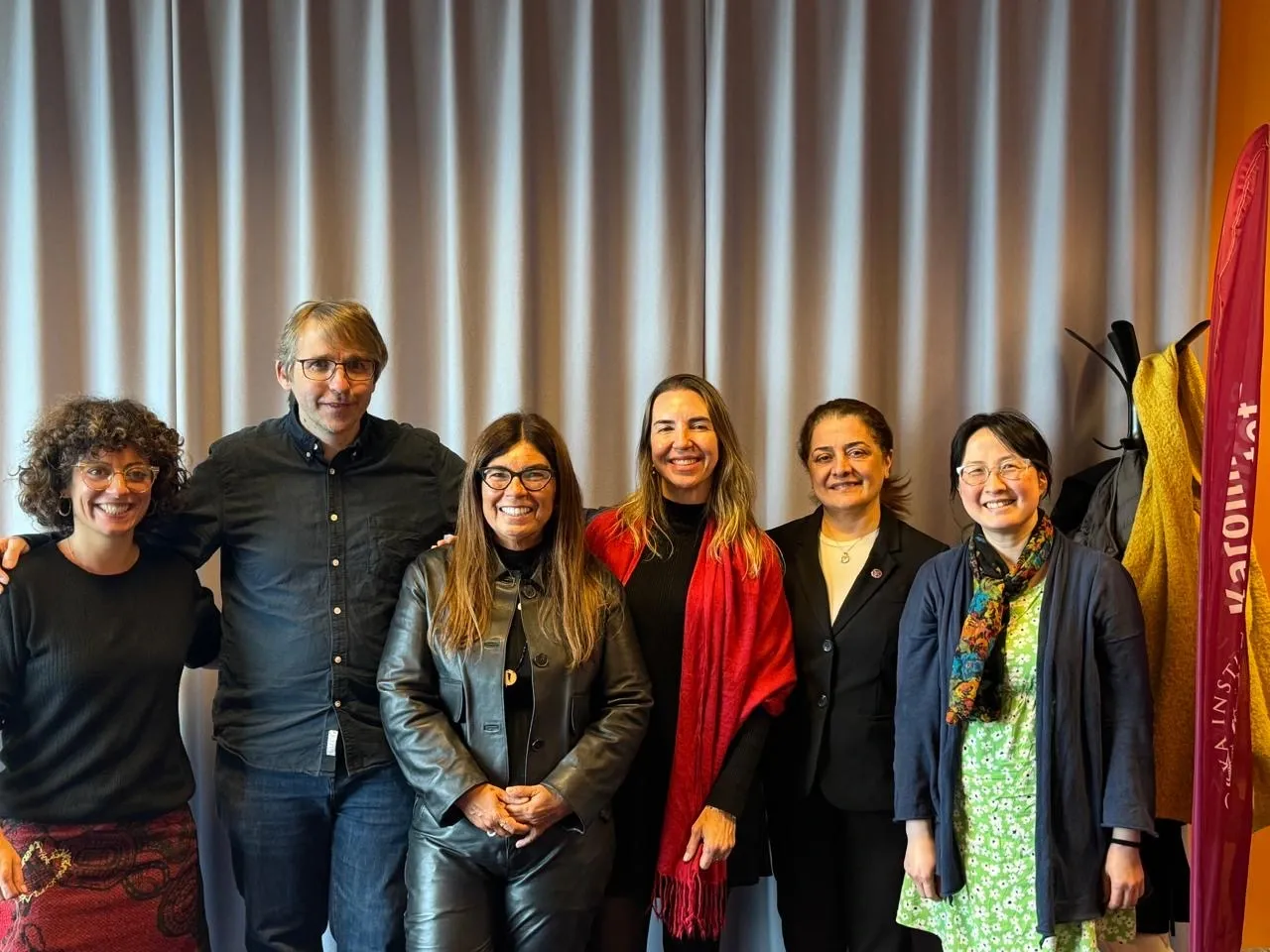 Six people standing side by side in a line for a group photograph; the accompanying caption lists their names and affiliations from left to right.