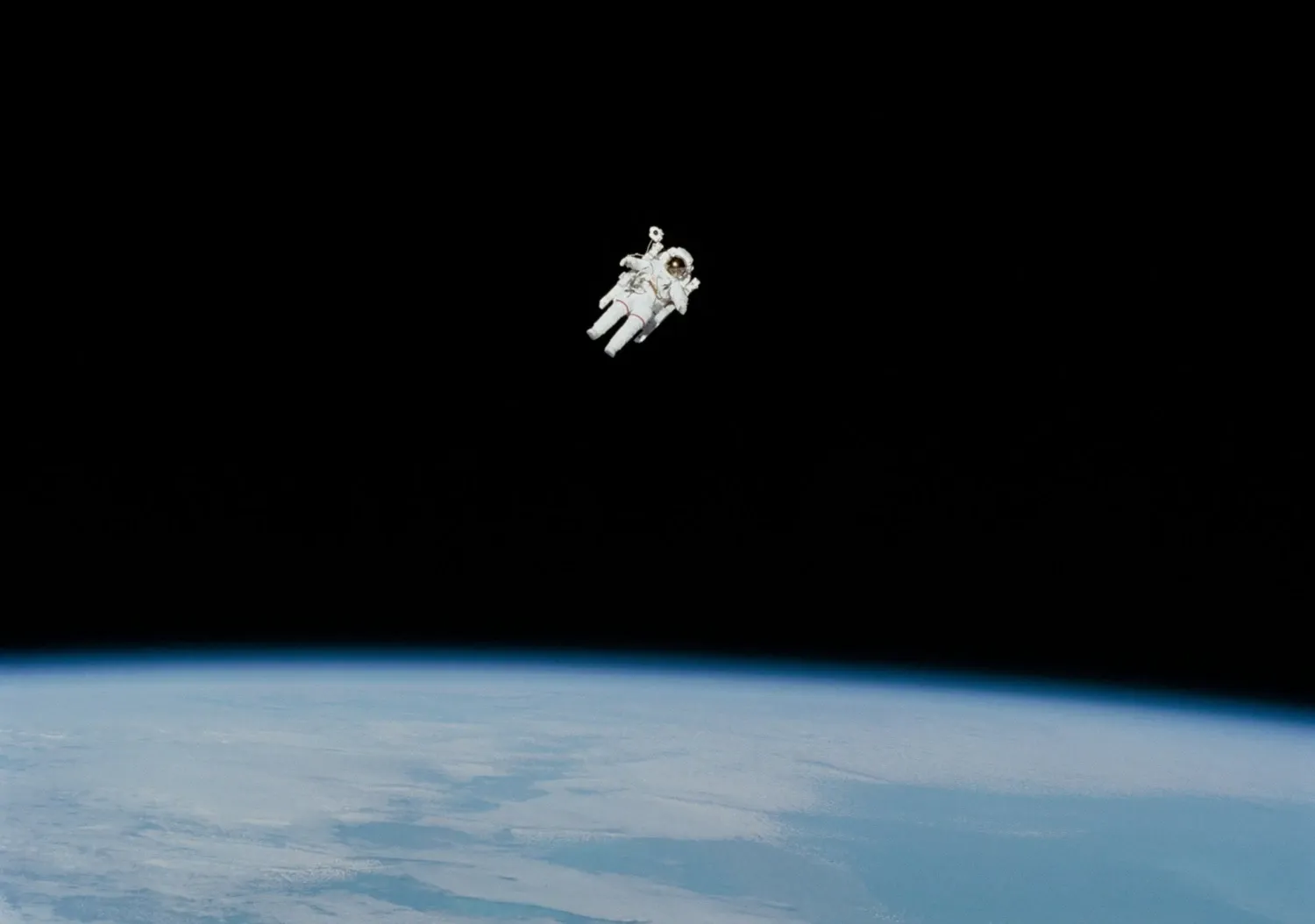 An astronaut is floating in space with the earth surface below
