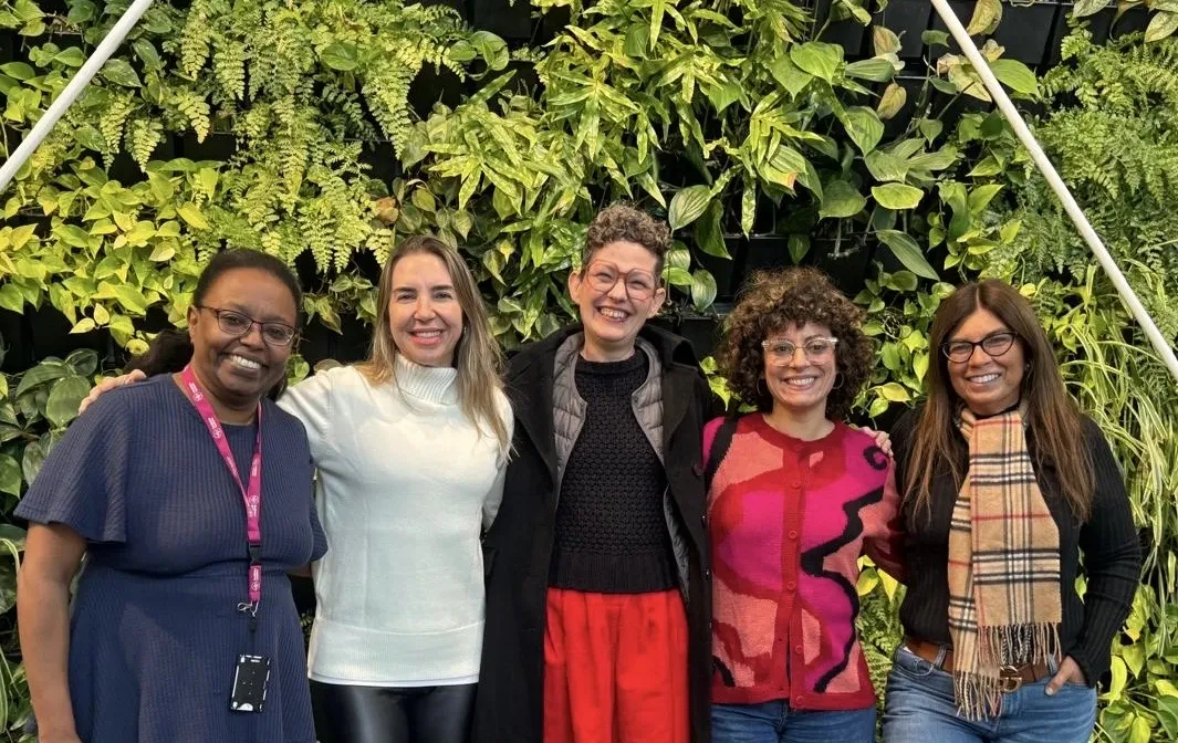 Five people standing side by side in a line for a group photograph; the accompanying caption lists their names and affiliations from left to right.