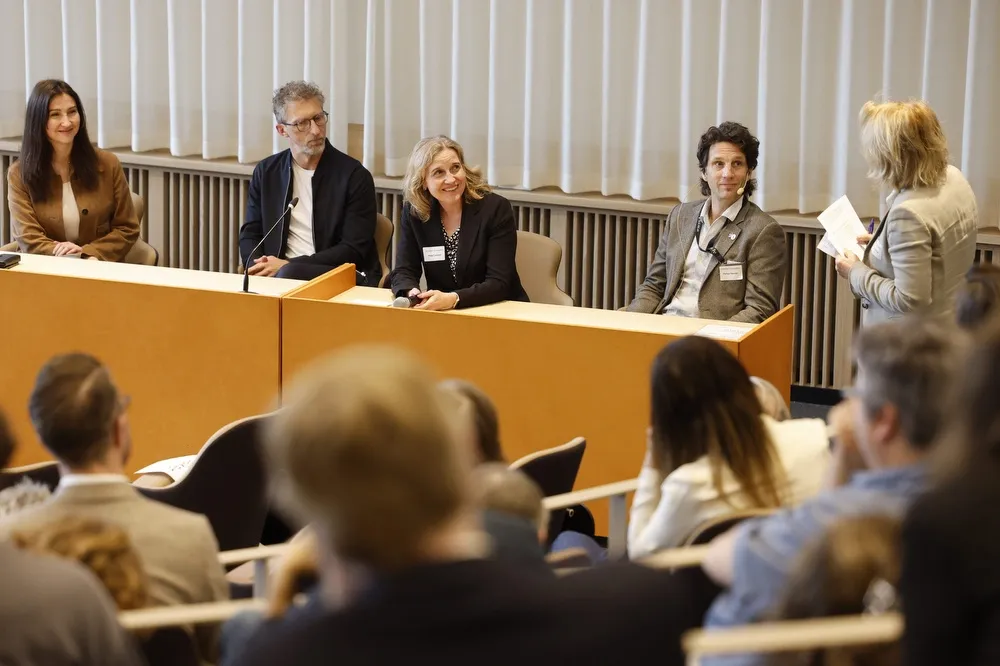 Four people sitting at a stage talking