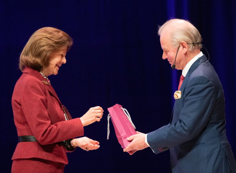 H.M. Queen Silvia receives a gift bag from KI's President Ole Petter Ottersen.
