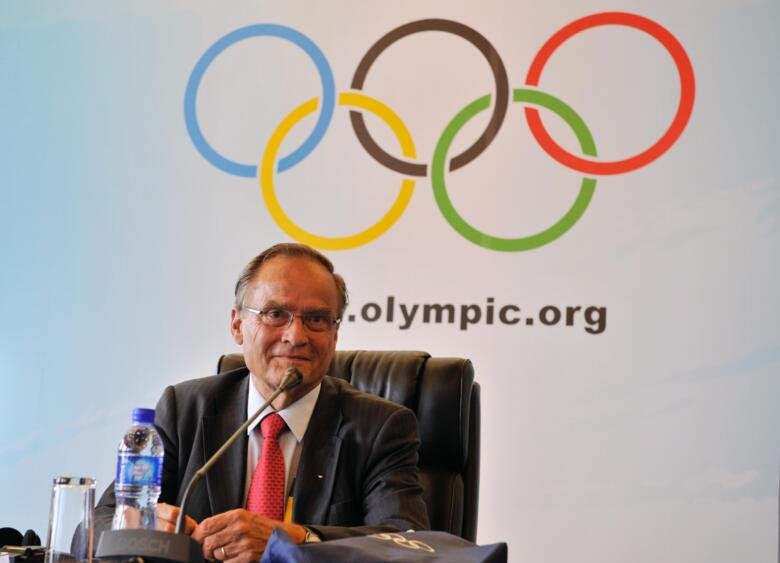 Arne Ljungqvist in front of the olympic symbol.
