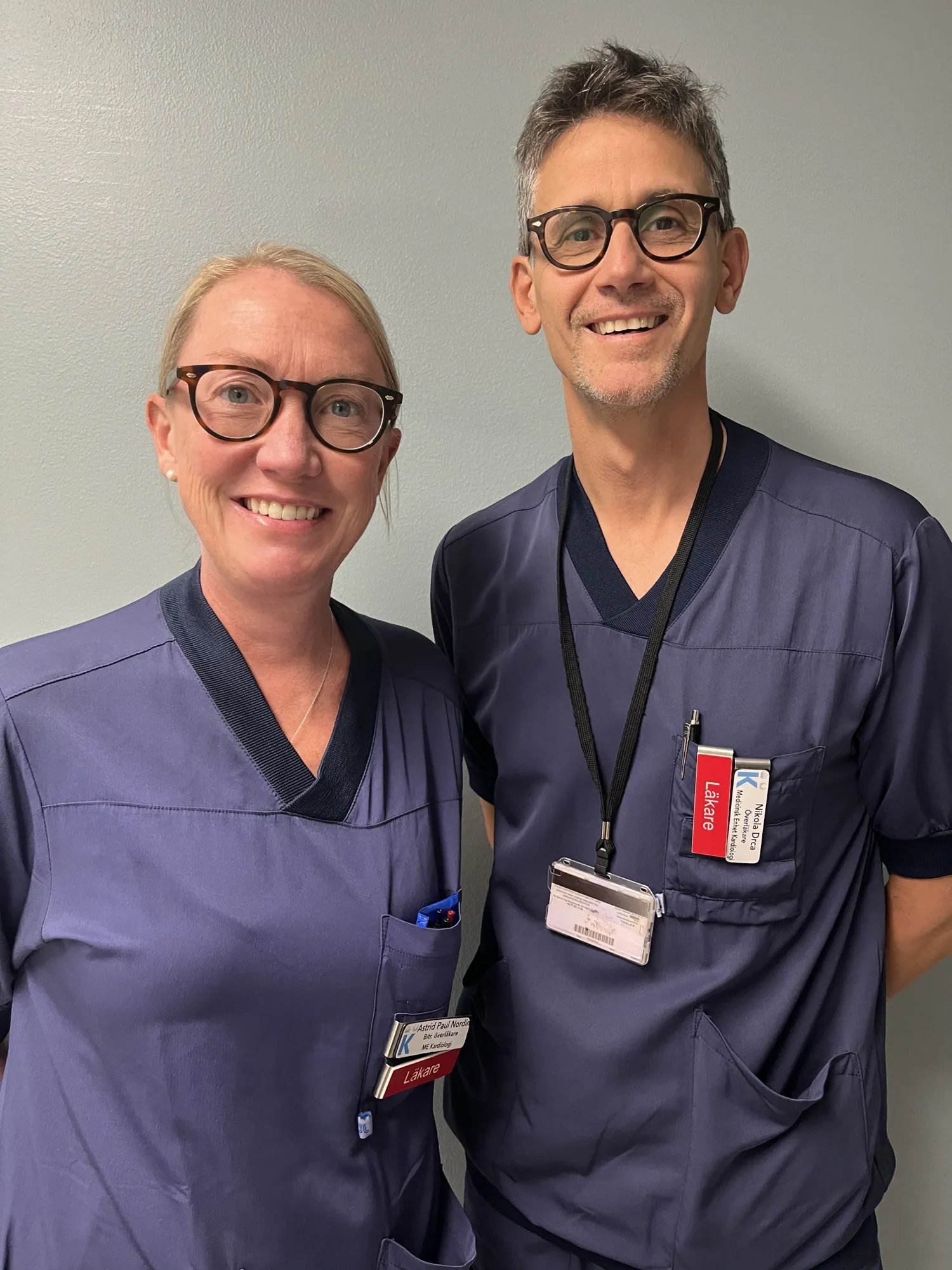 Portrait of a woman and a man wearing scrubs.