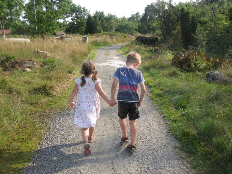 Two children walking away along a path