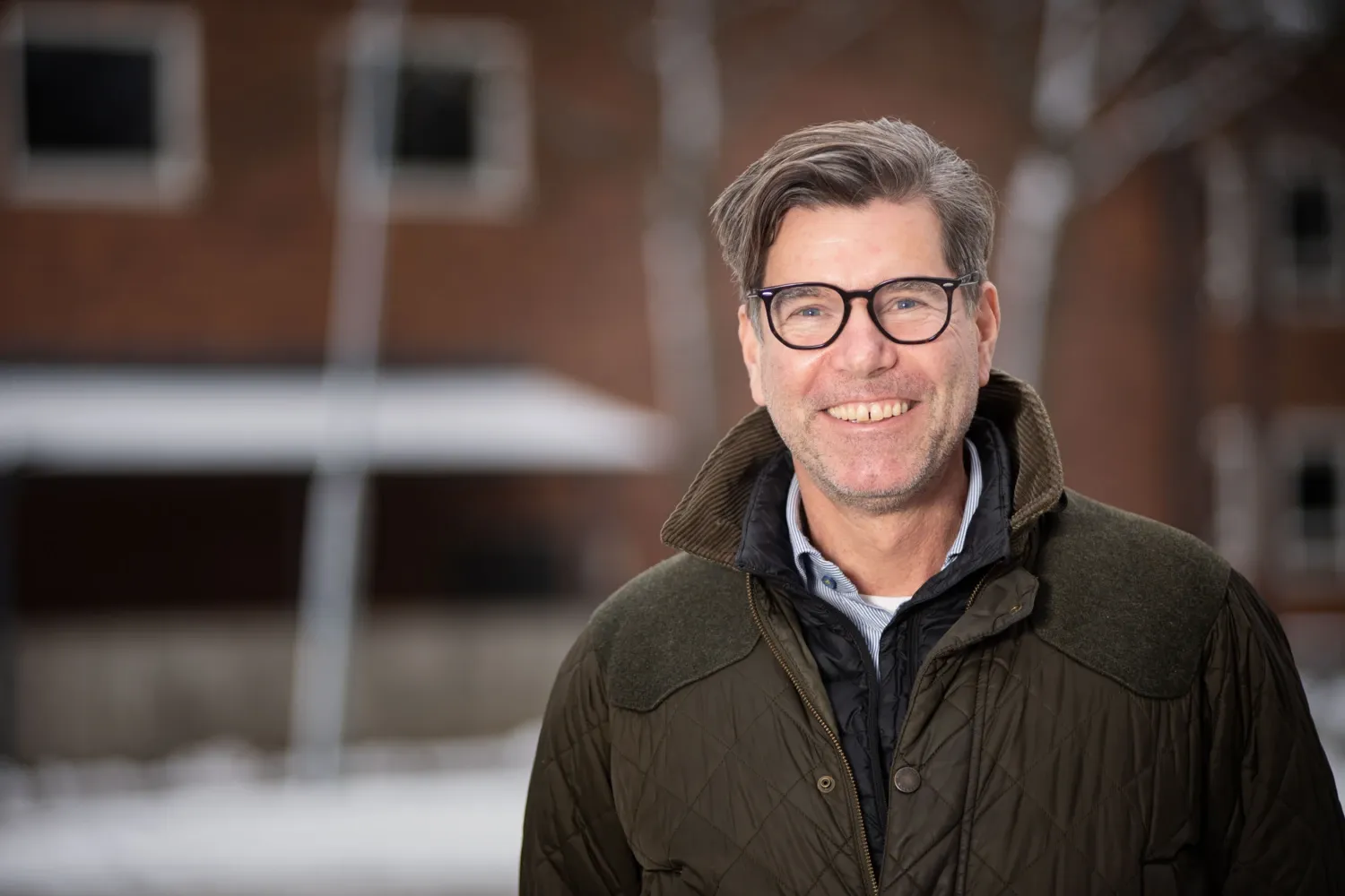 Portrait of Björn Kull outdoors with building in background.