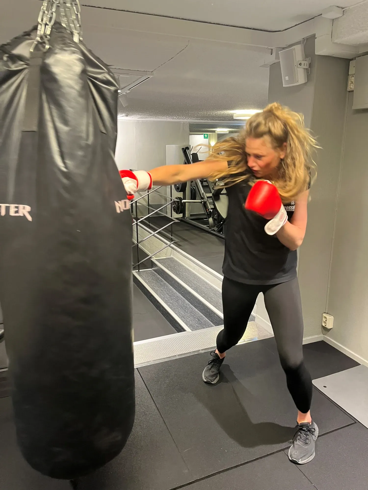 Pernilla Alencar Siljehag trains boxing at the gym and hits the punching bag with her right arm.