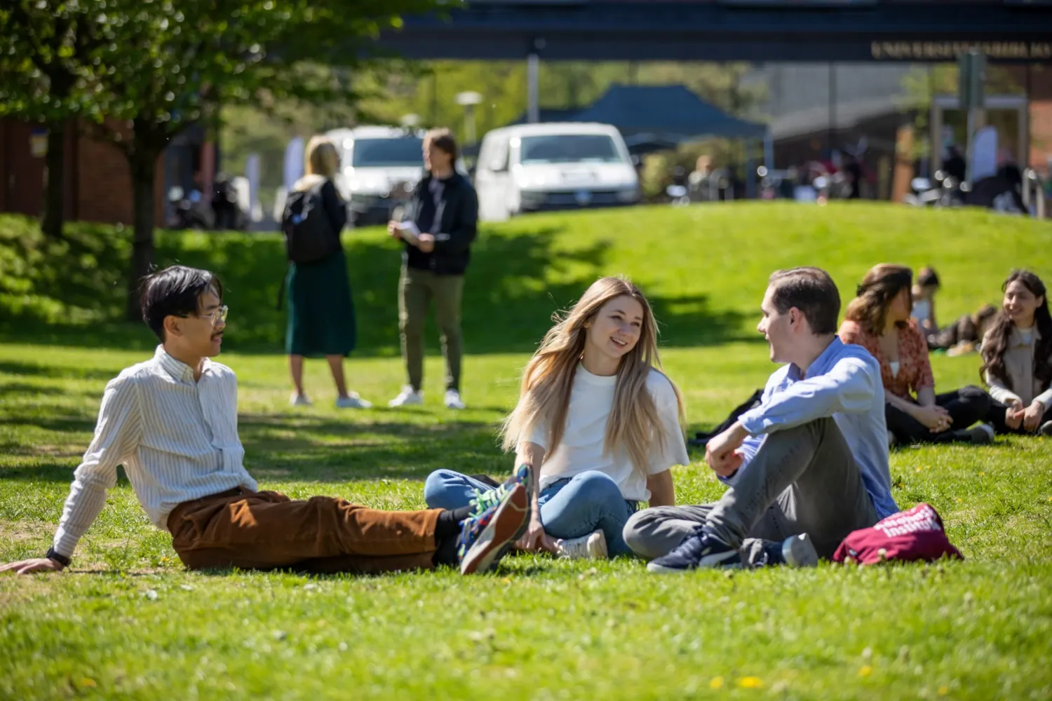 Students outside at campus Solna during a sunny spring day in 2022. || Students outside at campus Solna. || Students outside at campus Solna.