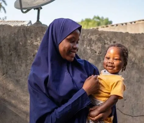 Amina,14 with her younger sibling Saratou, who has recently recovered from pneumonia, outside their home in Jigwa State, Nigeria