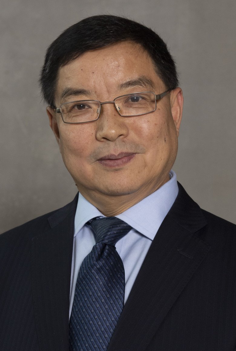 Portrait of Chengxuan Qiu, Aging Research Center (ARC), in suit, againt neutral background.