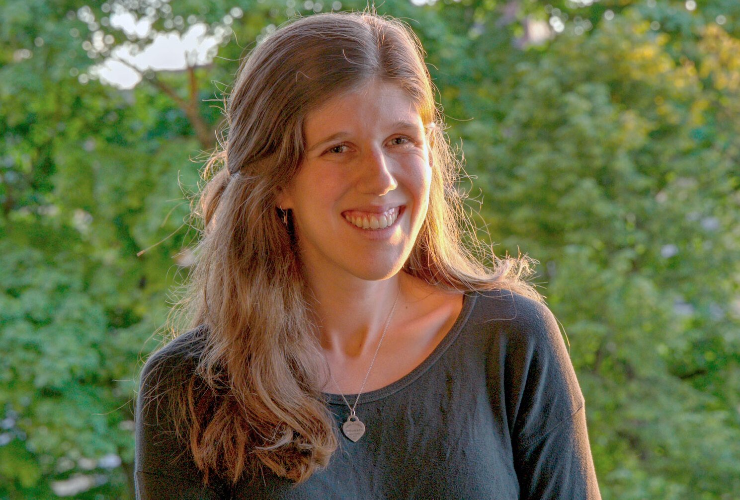Portrait taken outside with trees in the background.