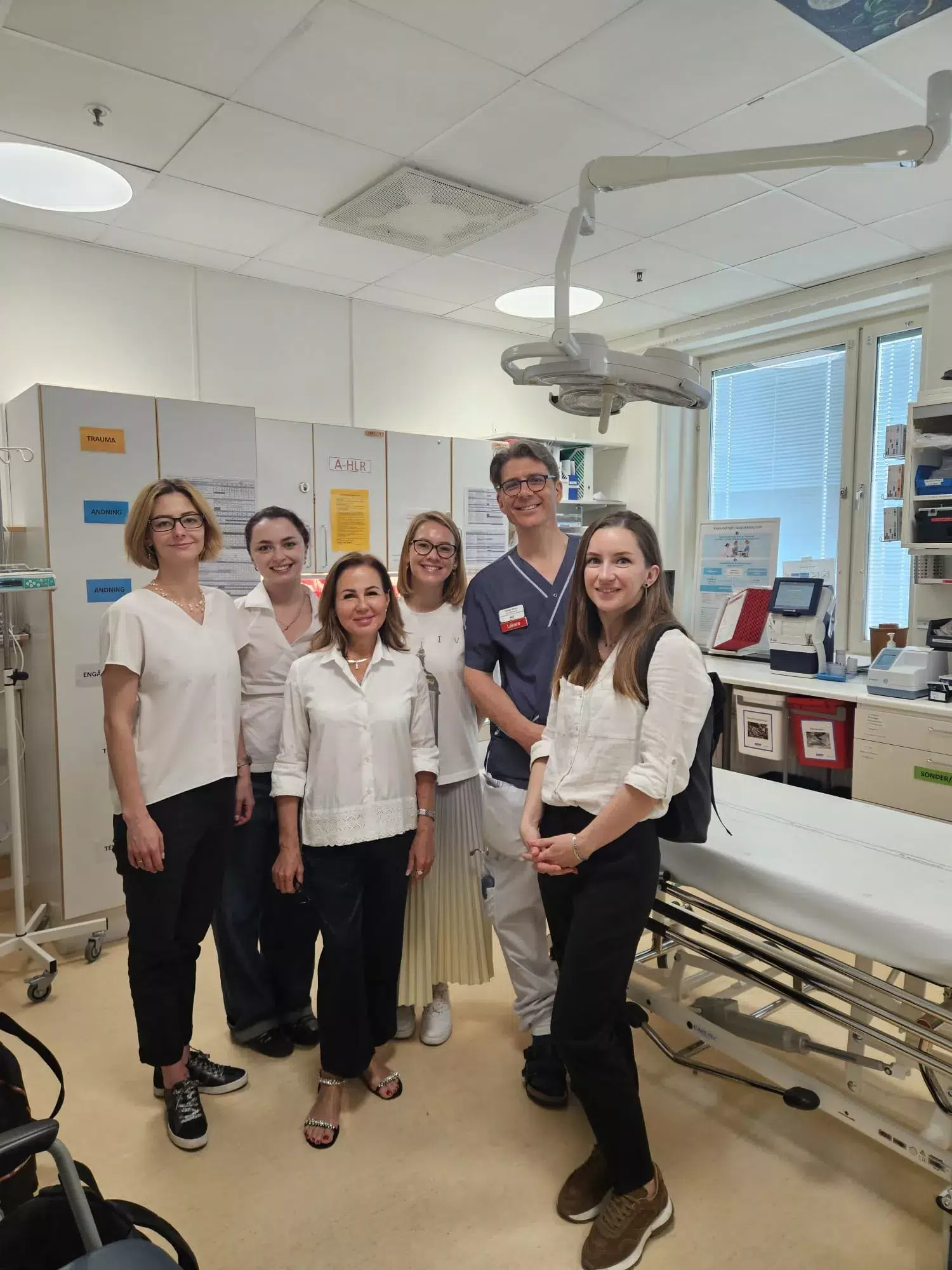 Visit to Sachsska Children's and Youth Hospital. Tobias LAfvén in hospital scrubs together with the four researchers from Ukraine.