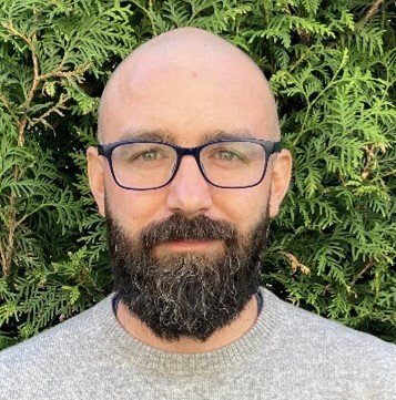 Close-up of Pablo Lopez standing in front of a green bush