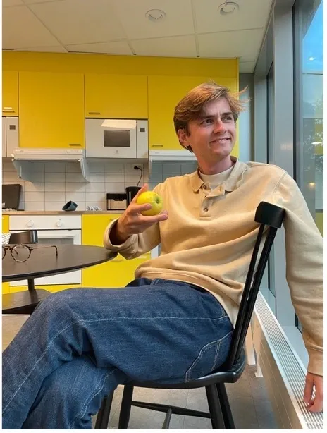 A picture of Erik Bassermann in the common kitchen, enjoying his view of nature