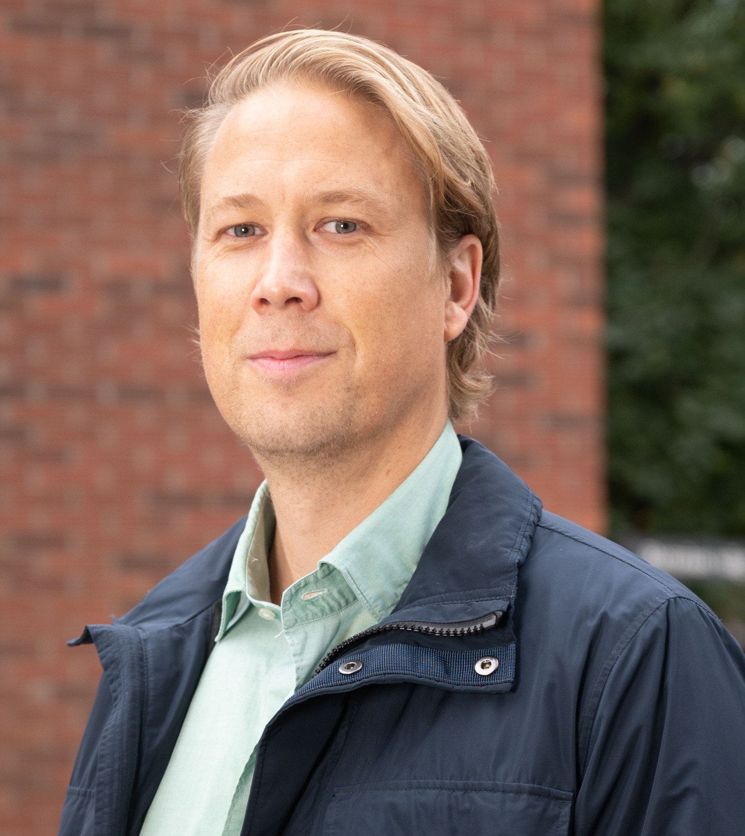 Portrait of Eric Westman in front of a brick wall outdoors.