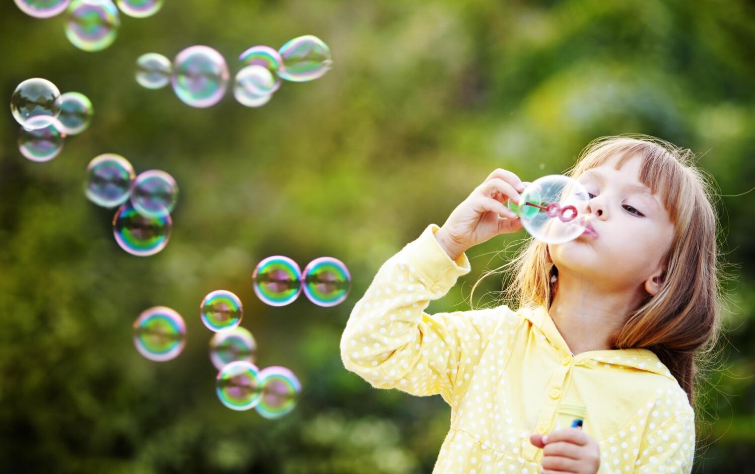 Young girl blowing bubbles.