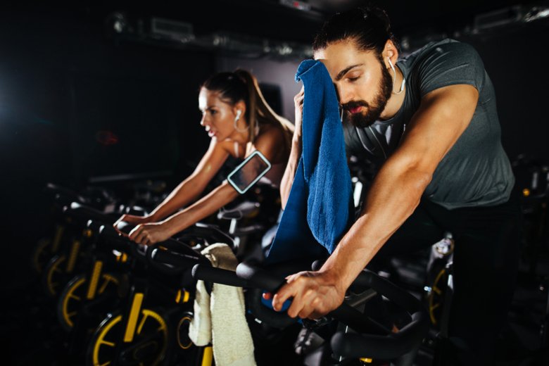 Photo of man and woman on exercise bikes.