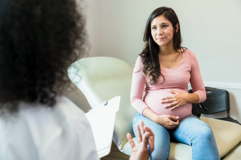 Pregnant woman talking to a doctor.