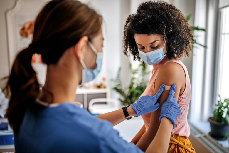 Woman gets plaster on her arm by a nurse.