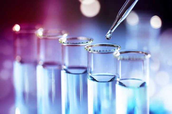 Laboratory test tube glassware with pipette dropper and flask.