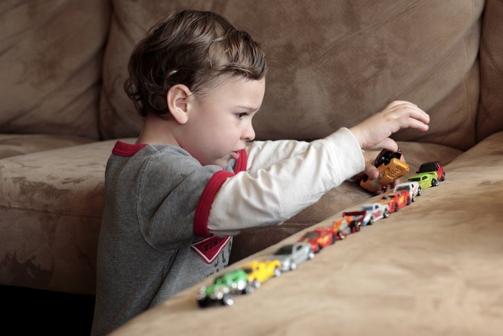 Young boy with autism playing with cars