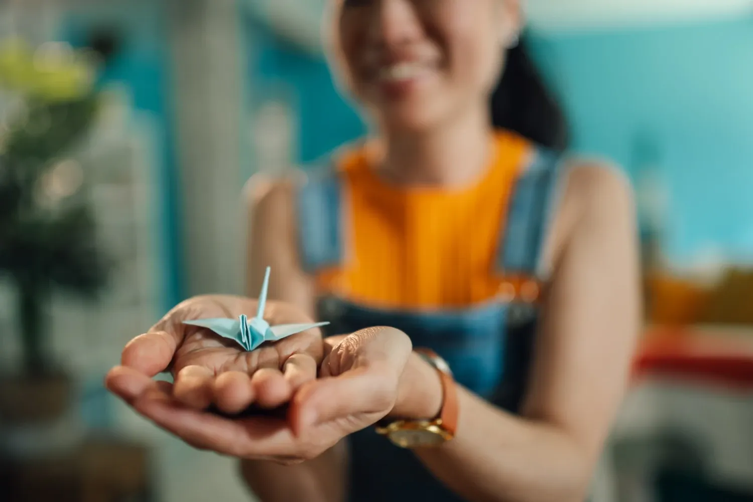 Girl holding folded paper in her hand.