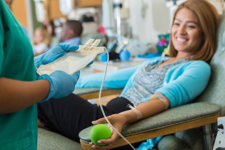 Female blood donor waiting while nurse is checking her information.