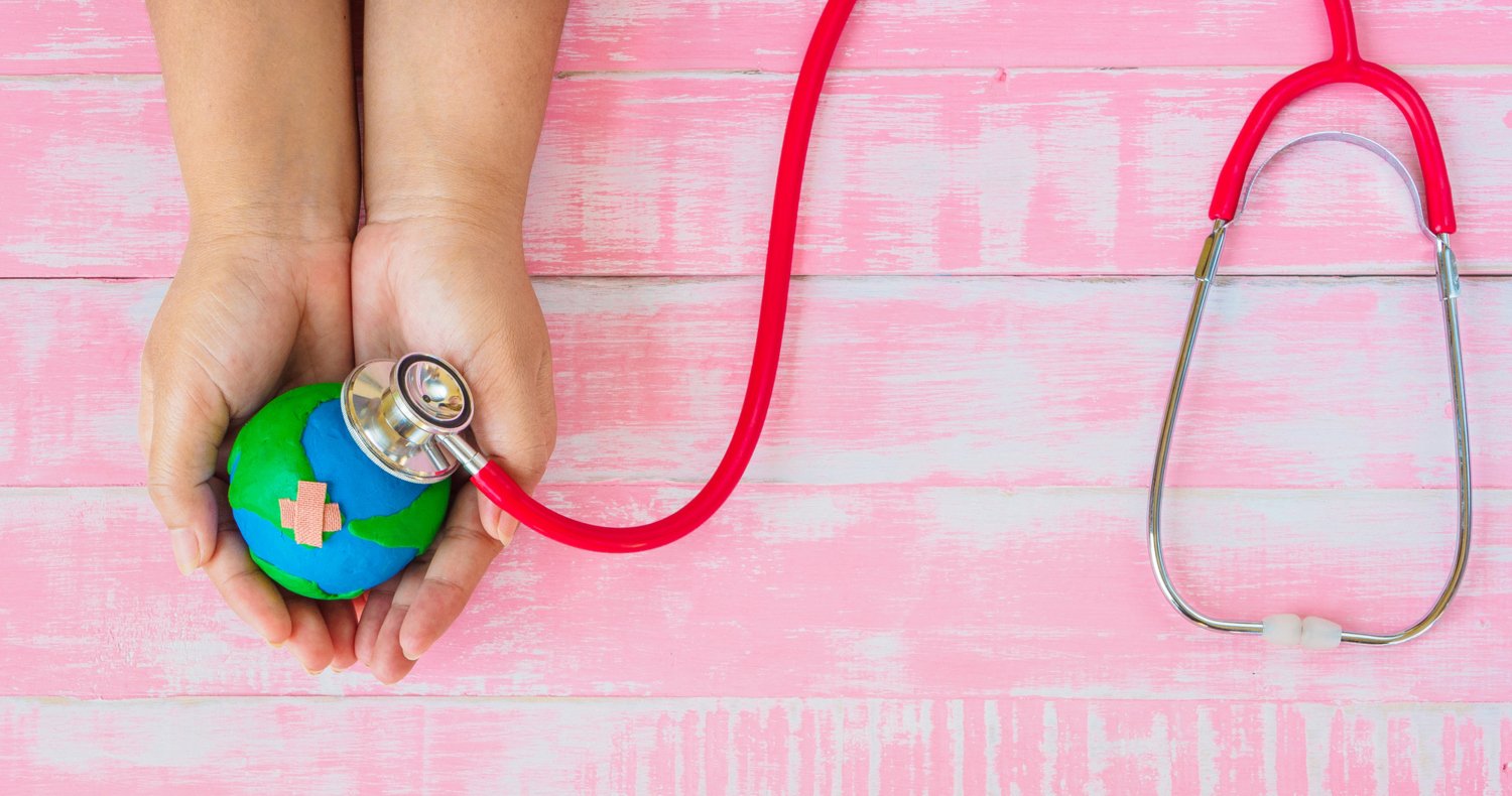 Symbolic illustration: hands holding a globe, which is being examined with a stethoscope.