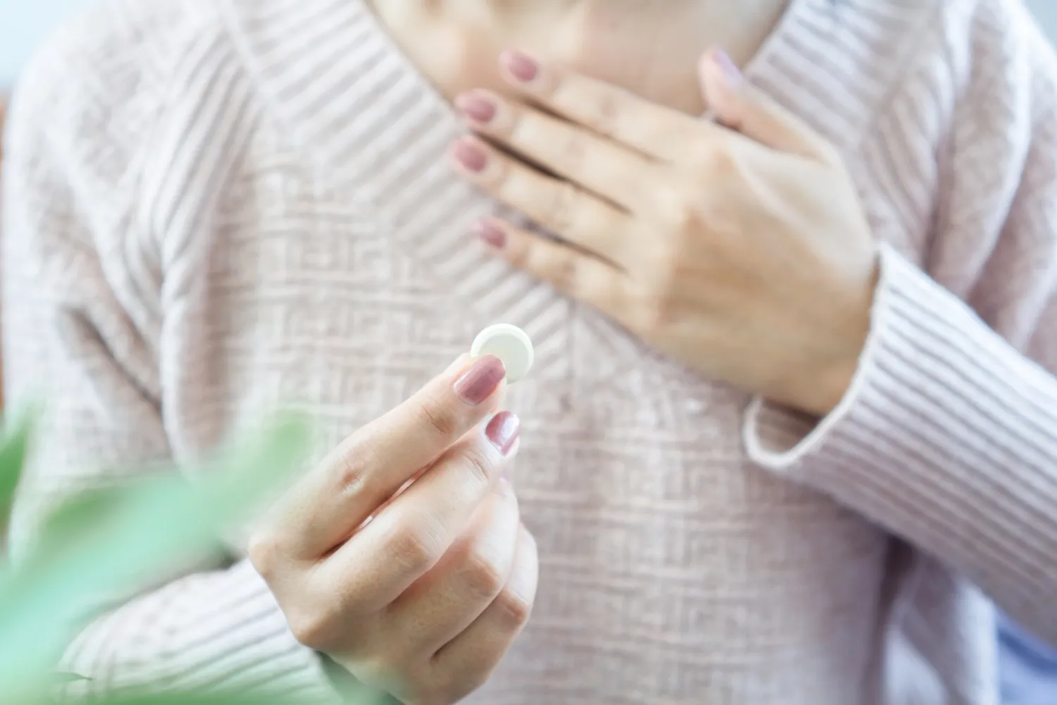 Woman with heartburn taking medicine.