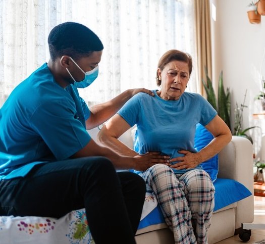 A woman with stomach pain being examined by a doctor. Photo: Getty Images