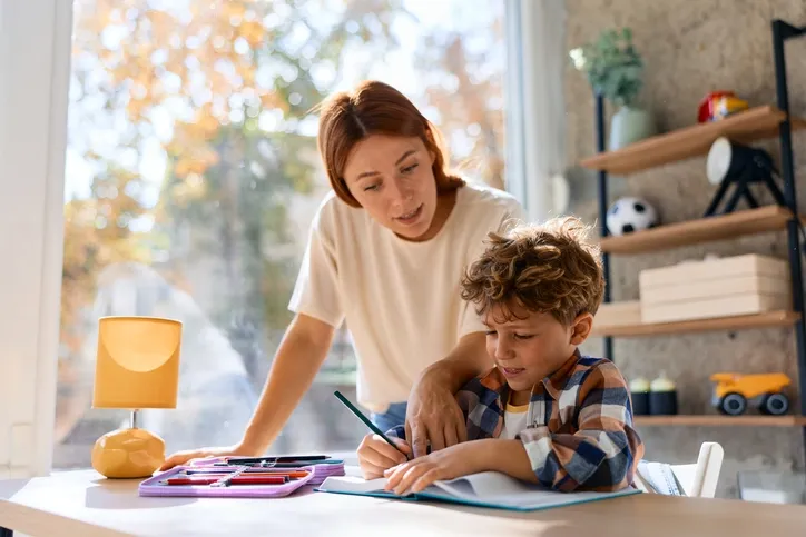 A mother helping her son doing his homework