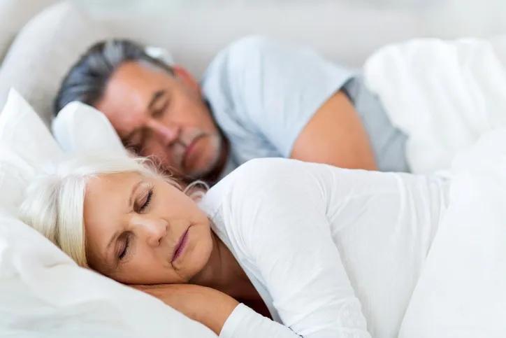 A couple lying in bed asleep