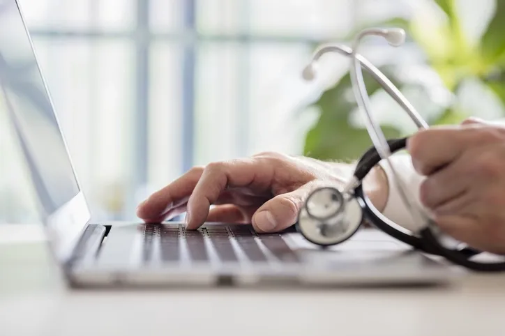 Doctor taking notes on a computer