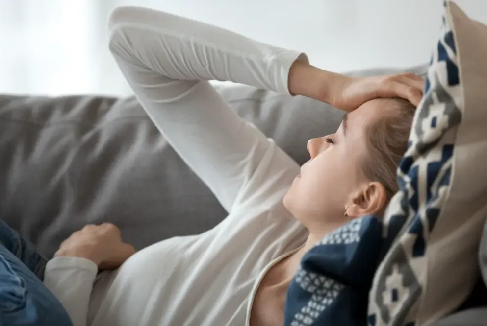 A woman in pain on the sofa