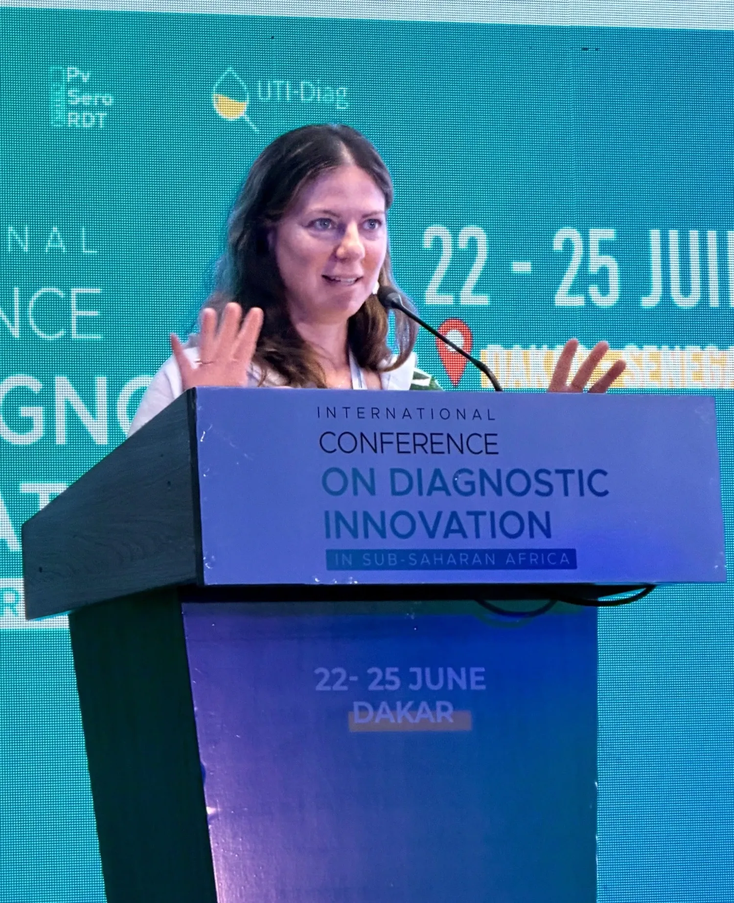 A woman standing behind a podium giving a speach.