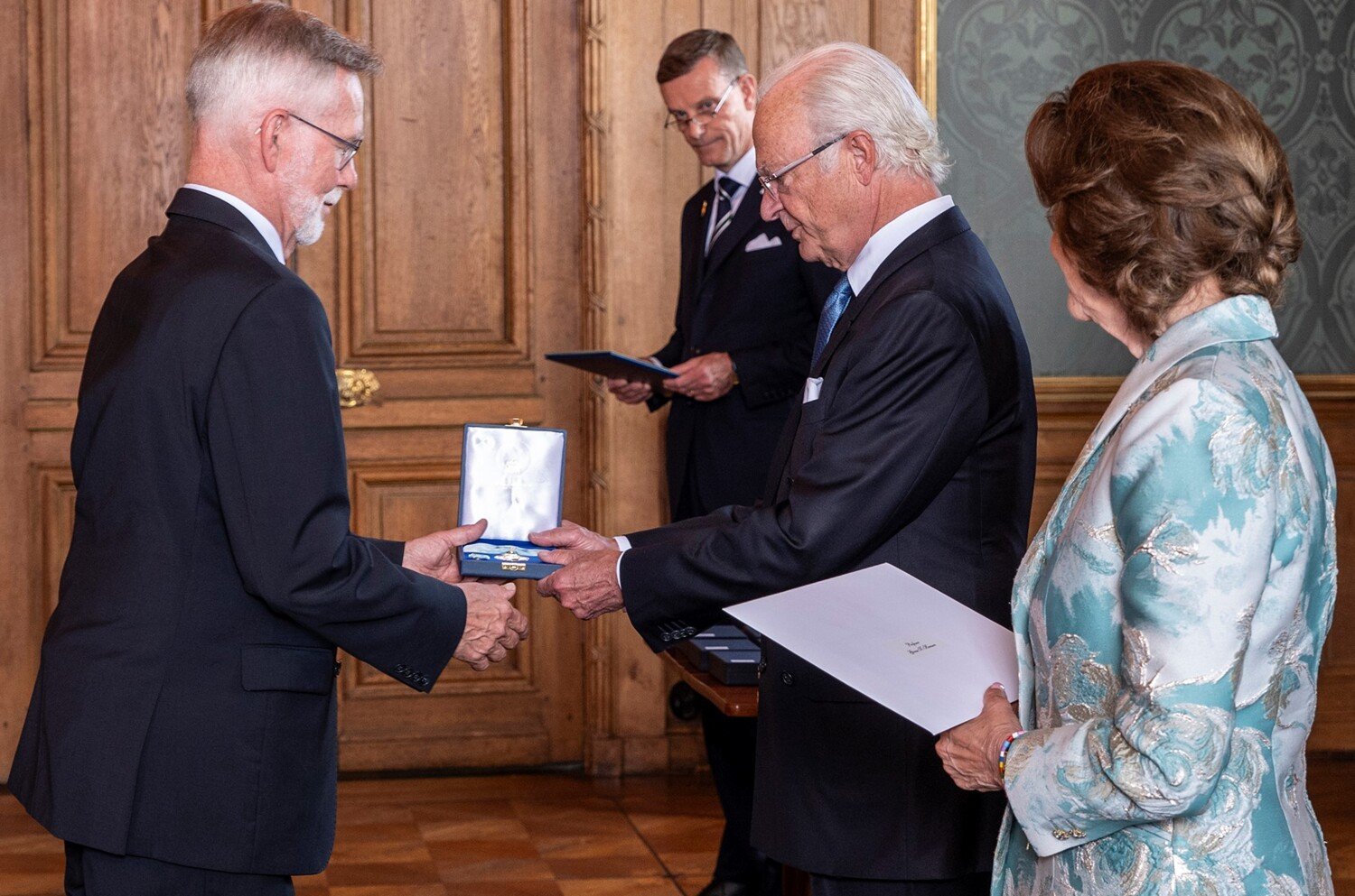 Professor Göran K Hansson receives his medal from The King, with Queen Silvia beside him.