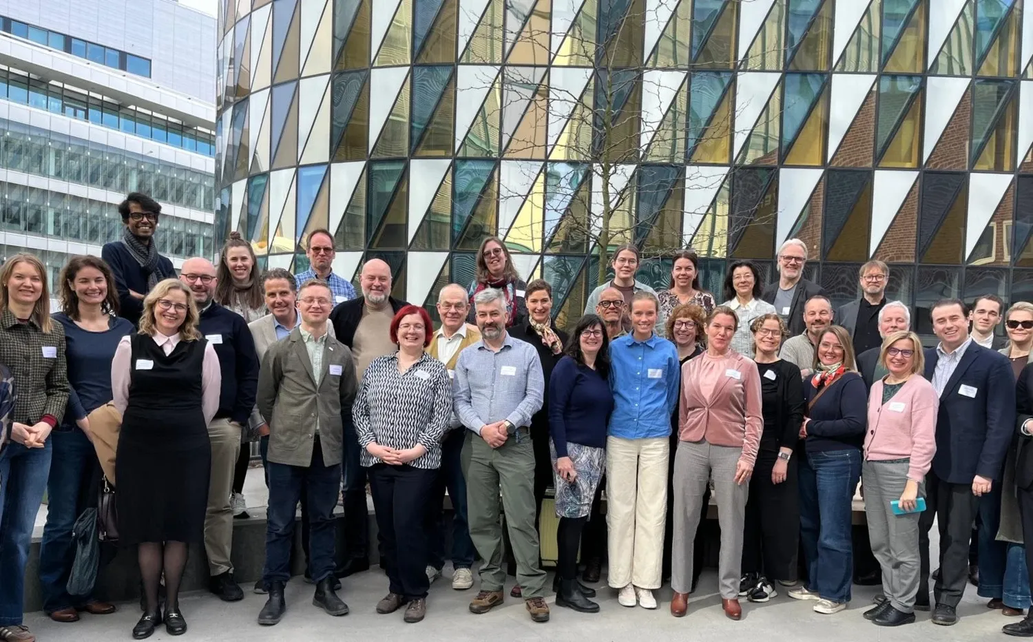 Group photo of people standing in front of the Aula Medica building