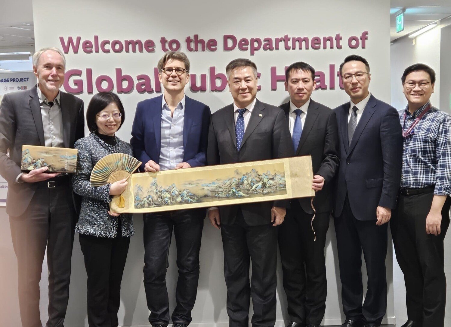 Group of people lined up in front of GPH sign.