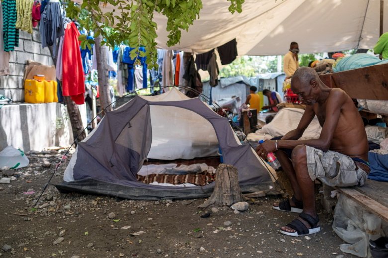 A man sits next to his tent at a shelter in Port-au-Prince, Haiti.
