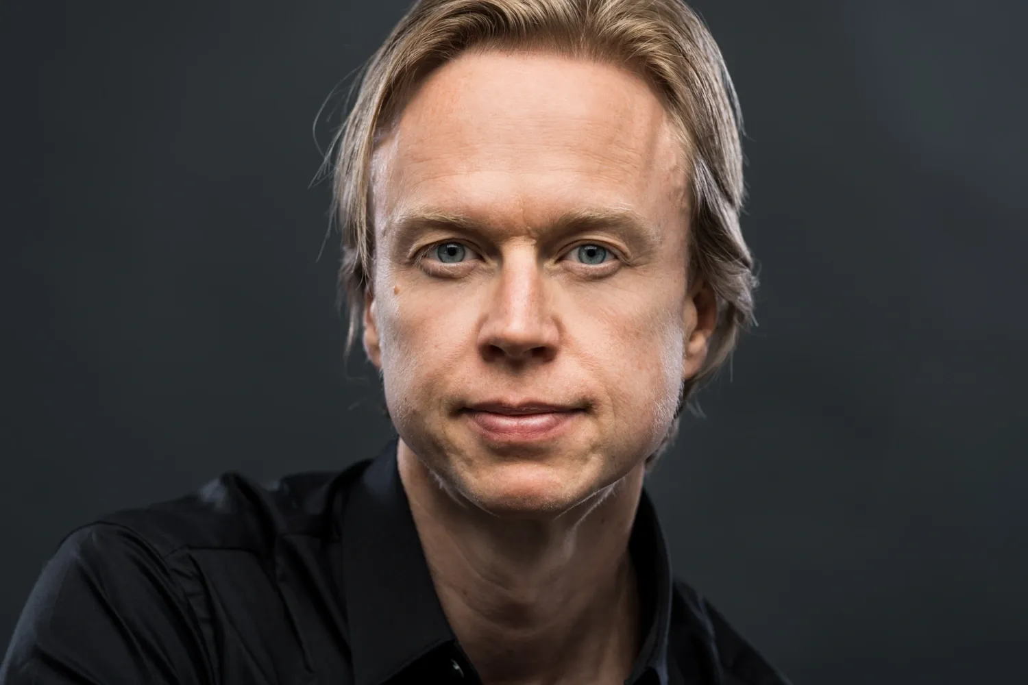 portait of Henrik Ehrsson against dark background.