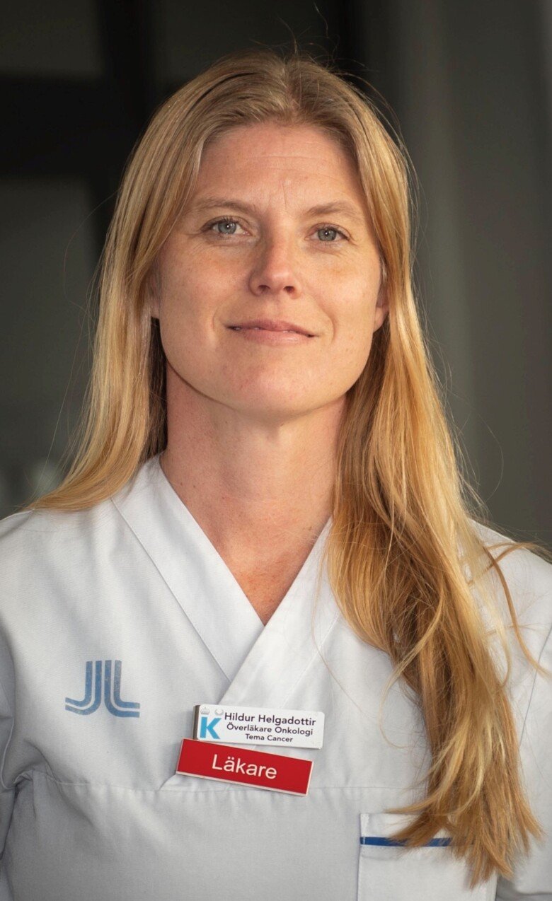 Portrait of Dr Hildur Helgadottir. She has long blond hair and is dressed in white scrubs.