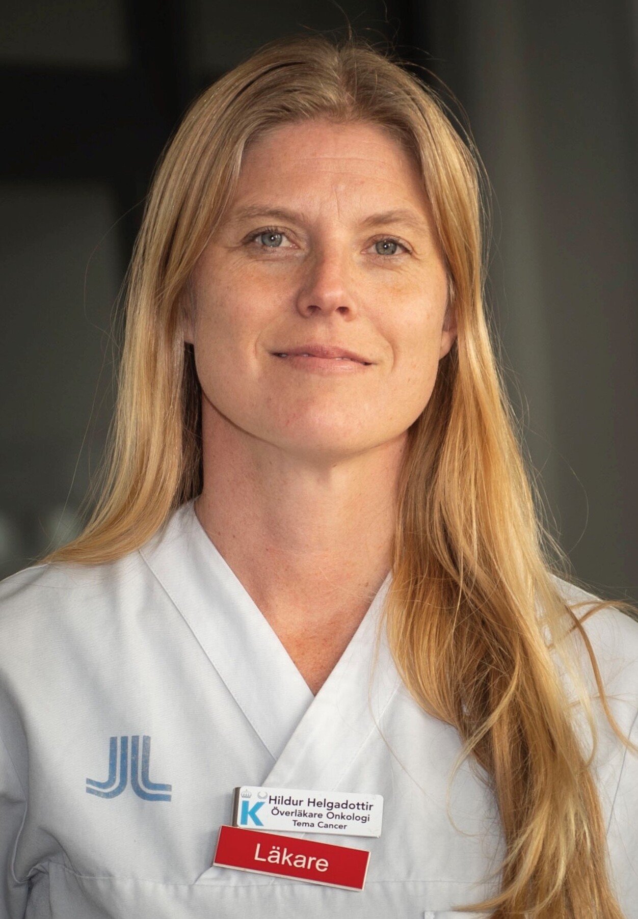 Portrait of Dr Hildur Helgadottir. She has long blond hair and is dressed in white scrubs.