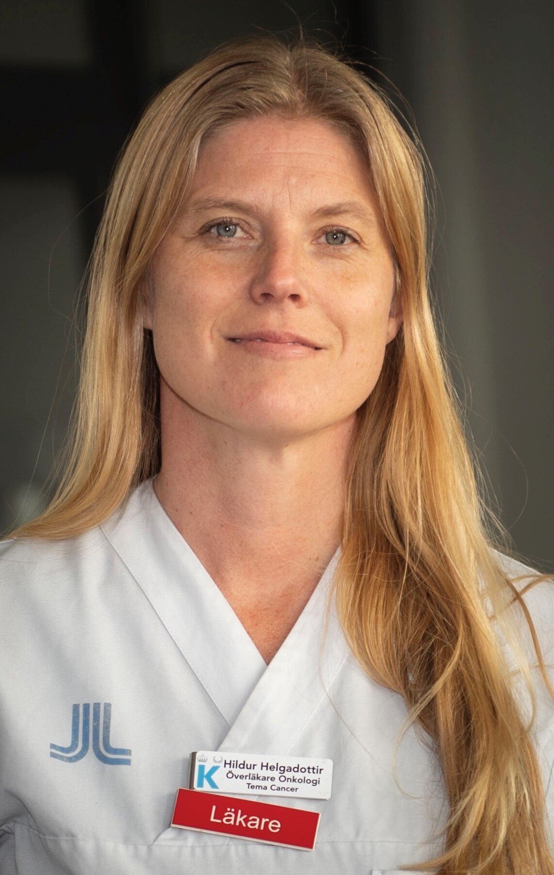 Portrait of Dr Hildur Helgadottir. She has long blond hair and is dressed in white scrubs.