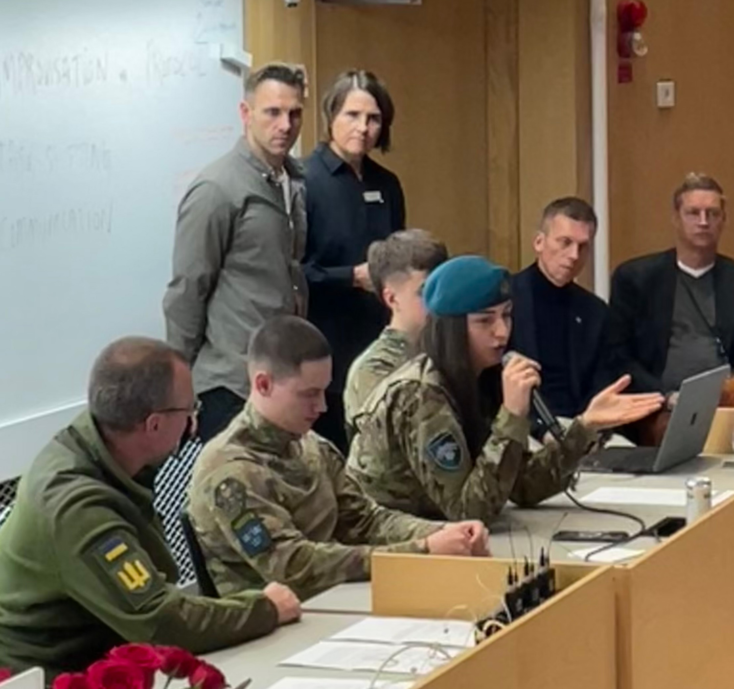 Ukrainian combat medics in a panel discussion in a large conference hall.