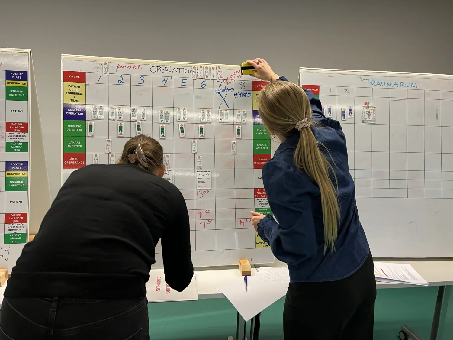 Two people standing in front of a whiteboard