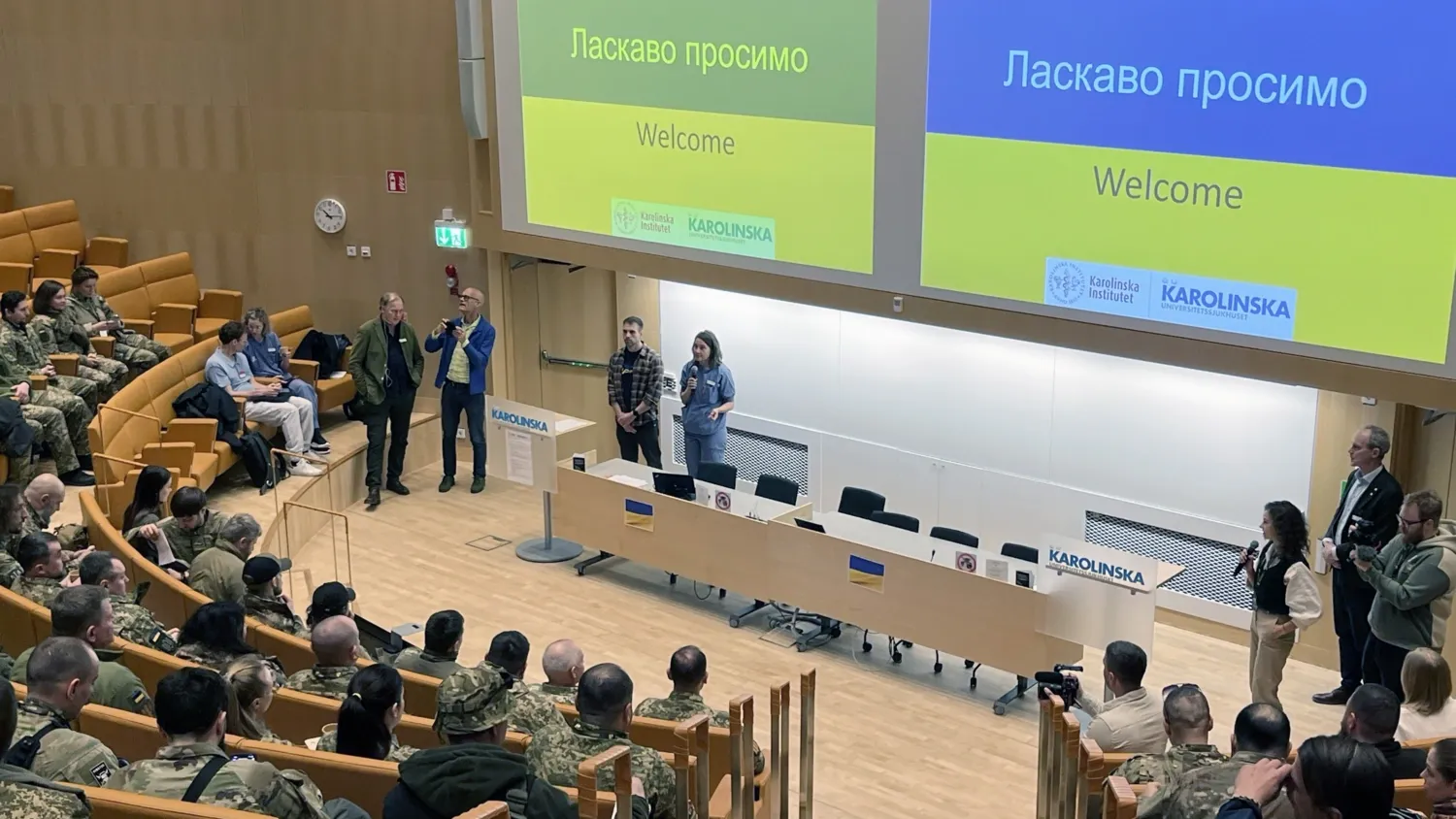 Ukrainian health workers visit Stockholm and gather in the auditorium. The screen displays the word ‘Welcome.’