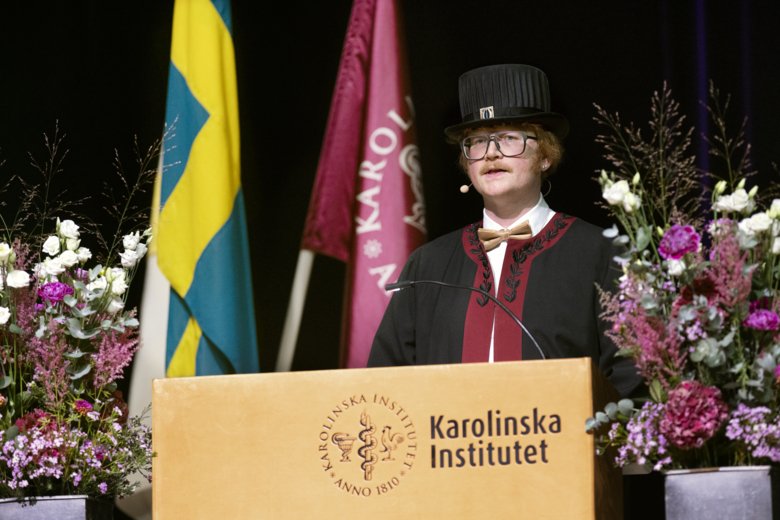 Brjánn Ljótsson stands at the flower-adorned podium and looks out at the audience.
