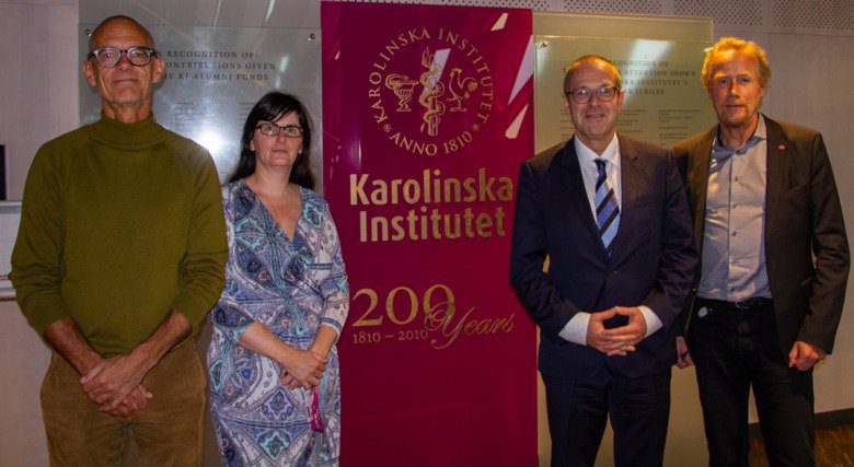 Four people standing in a line in front of a sign with KI's name and logo. The persons are, from left: Johan von Schreeb, Anna Zorzet, Hans Kluge, Anders Gustafsson